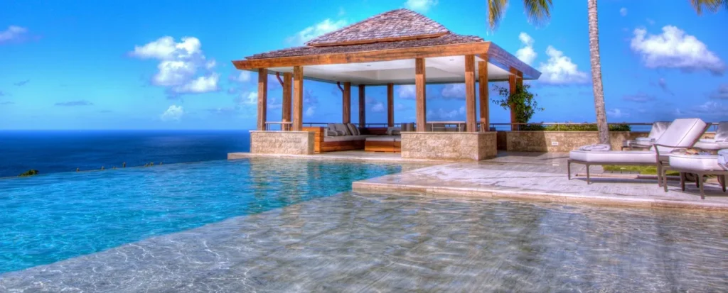 Swimming pool with a shade palapa looking out over the coastline